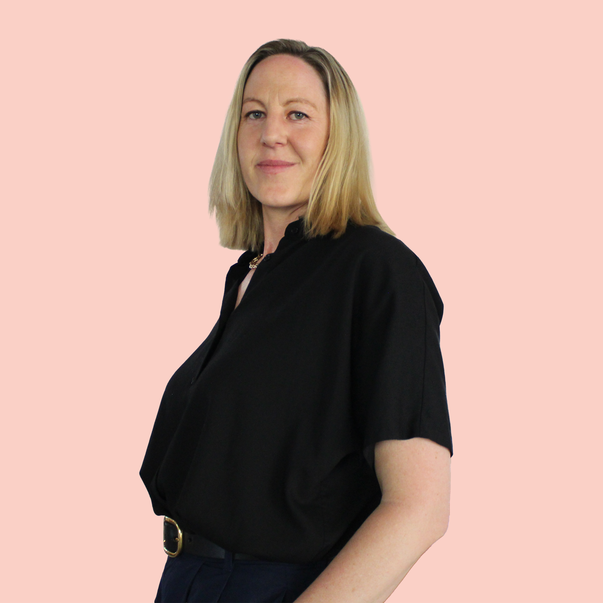 Portrait of a man with brown hair and glasses on a flat gray background.